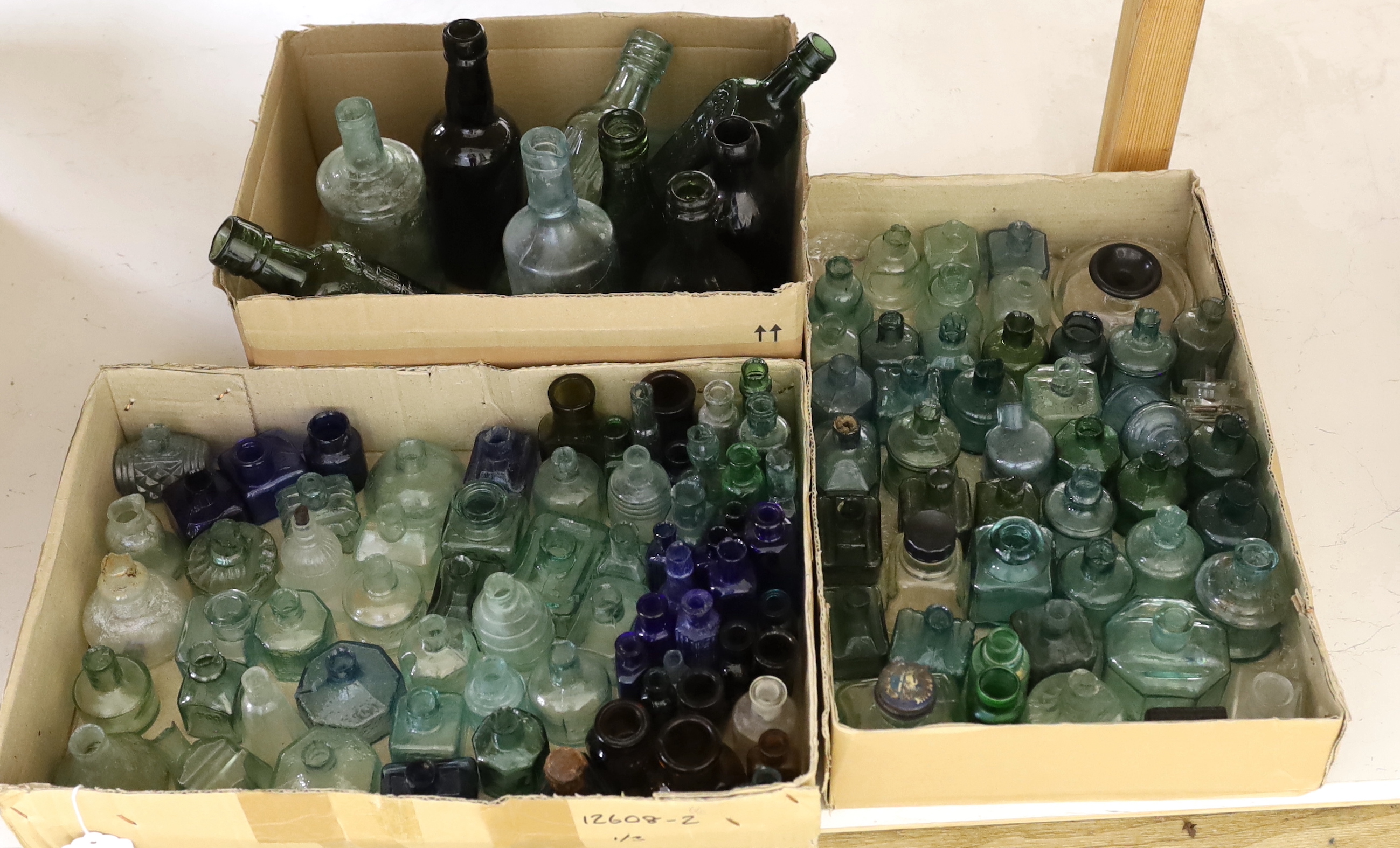 A collection of late 19th/early 20th century glass ink bottles, drink bottles and sauce bottles, brand names and advertising moulded into the glass on a number of examples, many ink bottles with pen rests moulded into th
